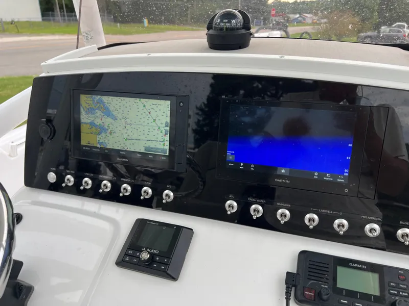 Slide: The Image of The dashboard of a 2021 Sportsman Open 232 Center Console boat with navigation screens and controls. - 18