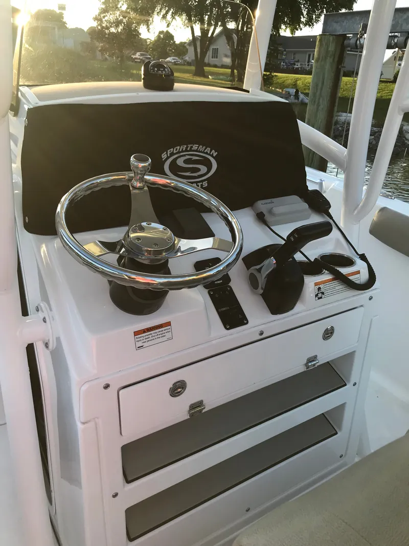 Slide: The Image of The image shows the helm of a 2021 Sportsman Open 232 Center Console boat. - 3