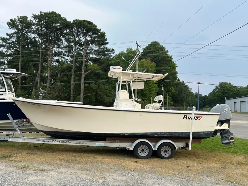 Slide: The Image of A 2004 Parker 25 Special Edition boat on a trailer, parked beside another boat. - 13