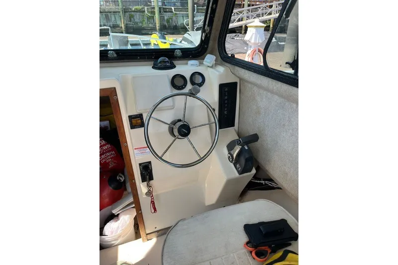 Slide: The Image of Steering wheel and controls inside a 2001 Parker 2320 Sport Cabin boat. - 4