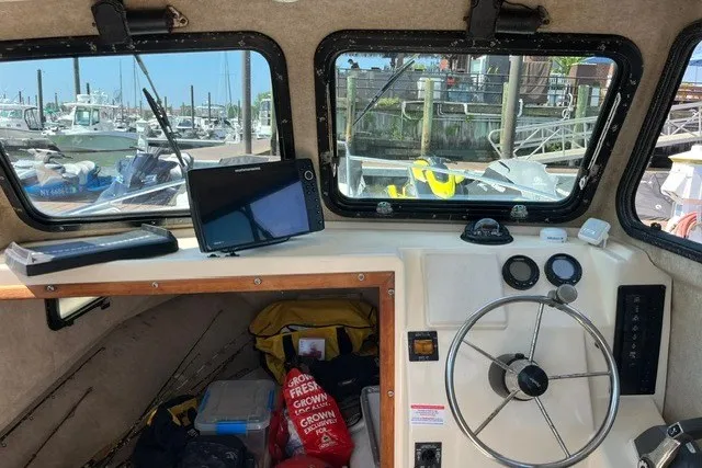 Slide: The Image of Interior of a 2001 Parker 2320 Sport Cabin boat with steering wheel and navigation equipment. - 5