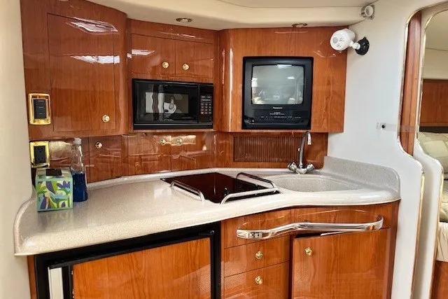 Slide: The Image of Luxurious 2001 Sea Ray 340 Amberjack yacht kitchen with wood cabinetry and modern appliances. - 8
