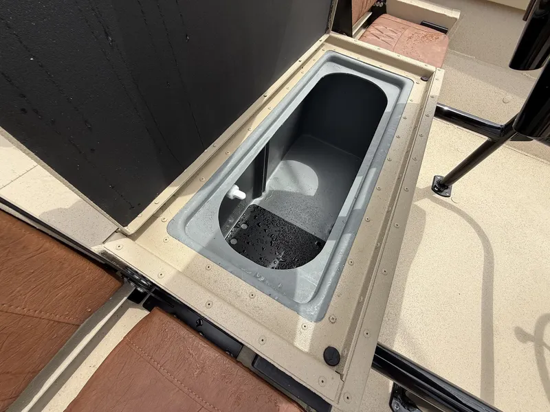 Slide: The Image of An open storage compartment on a boat with brown upholstery and black railing. - 9