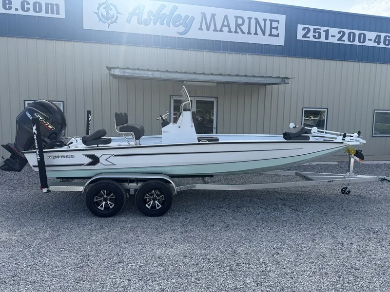 The Image of A white Xpress boat, model Hyper-Lift Bay Series H22B-175 SHO, sits on a trailer in front of a building. - 1