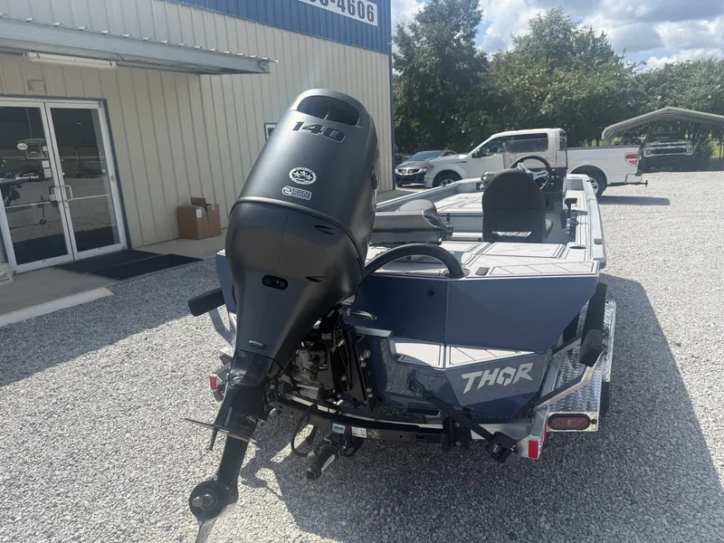 Slide: The Image of Thor Lake Hammer 1900 SC 2027 with a powerful outboard motor on a gravel lot. - 6
