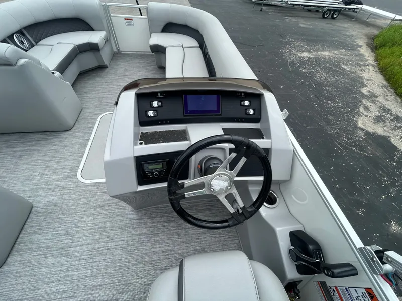 Slide: The Image of The image shows the cockpit of a 2021 Bennington 23LSBSD with gray upholstery and a modern helm. - 9