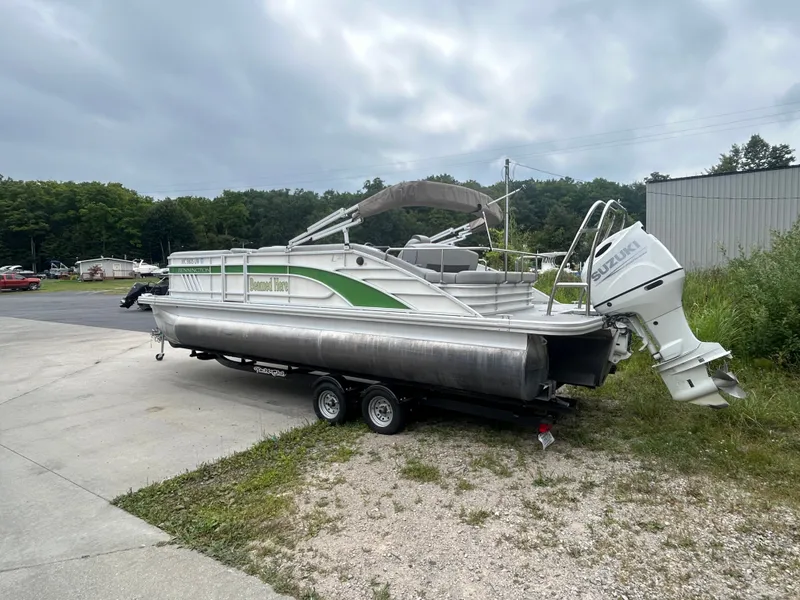 Slide: The Image of A 2021 Bennington 23LSBSD pontoon boat on a trailer. It features an outboard motor. - 4