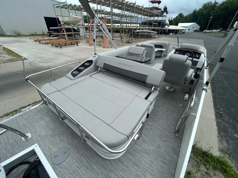 Slide: The Image of The image shows a 2021 Bennington 23LSBSD pontoon boat with gray upholstery and cup holders. - 14