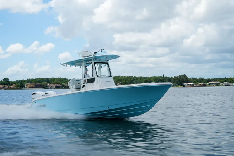 Slide: The Image of 2027 Pathfinder 2800 Hybrid boat cruising on a calm lake under a cloudy sky. - 21
