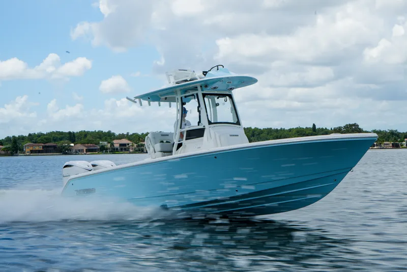 The Image of 2027 Pathfinder 2800 Hybrid boat cruising on a lake under a cloudy sky. - 0