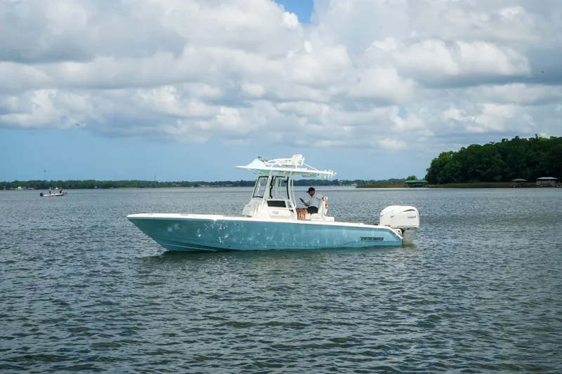 Slide: The Image of 2027 Pathfinder 2800 Hybrid boat on a calm lake under cloudy skies. - 13