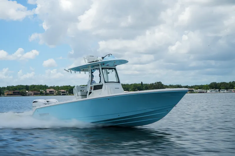 Slide: The Image of 2027 Pathfinder 2800 Hybrid boat cruising on a lake under a cloudy sky. - 22