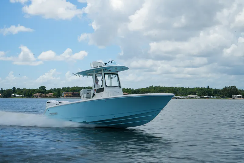 Slide: The Image of 2027 Pathfinder 2800 Hybrid boat cruising on a calm lake under a cloudy sky. - 19