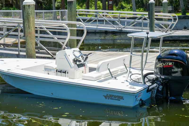 Slide: The Image of 2027 Hewes Redfisher 16 boat docked, featuring Yamaha outboard motor, in a serene marina setting. - 36
