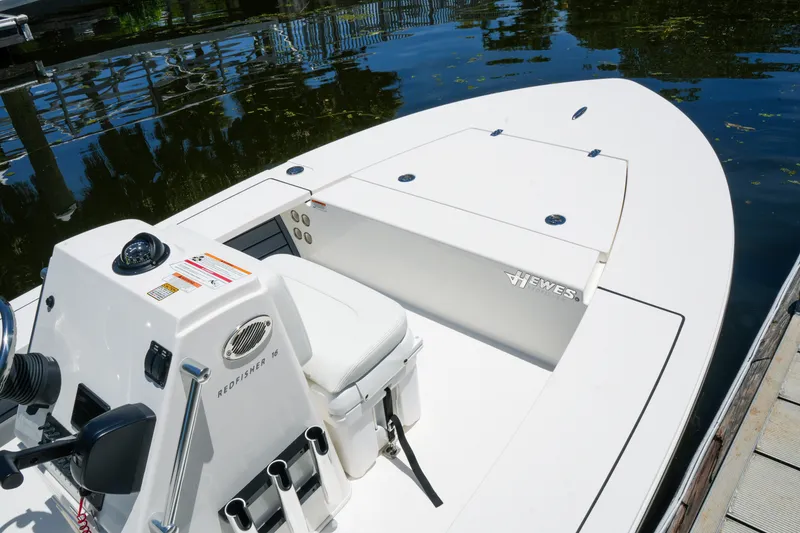 Slide: The Image of 2027 Hewes Redfisher 16 boat docked on calm water, showcasing sleek design. - 25