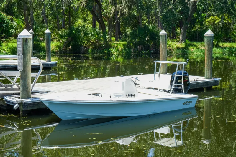 Slide: The Image of 2027 Hewes Redfisher 16 boat docked on a serene, wooded lake. - 29