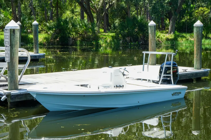 The Image of 2027 Hewes Redfisher 16 boat docked on a serene, wooded lake. - 0