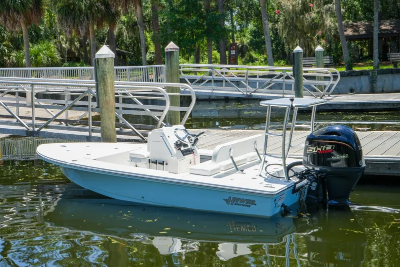 Slide: The Image of 2027 Hewes Redfisher 16 boat docked by a scenic marina with lush greenery. - 35