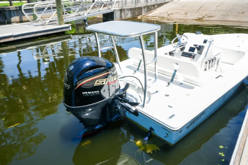 Slide: The Image of 2027 Hewes Redfisher 16 boat with Yamaha outboard motor docked in calm water. - 18