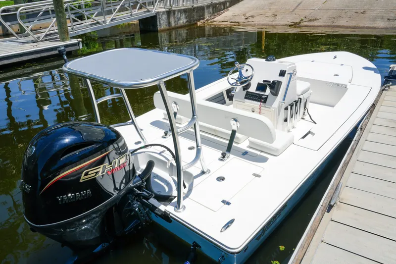 Slide: The Image of 2027 Hewes Redfisher 16 boat docked, featuring Yamaha engine and sleek design. - 21