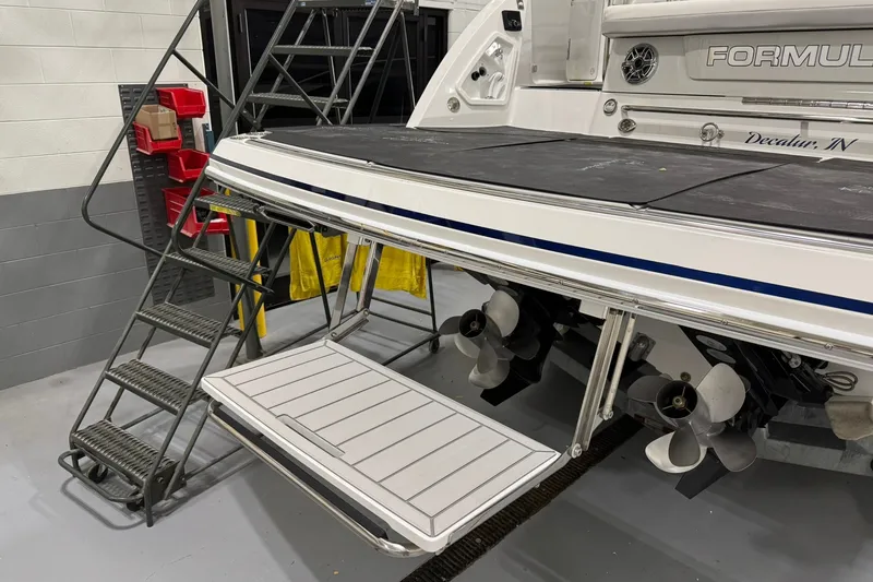 Slide: The Image of 2026 Formula 360 Crossover Bowrider I/O with swim platform and dual propellers in a garage. - 15