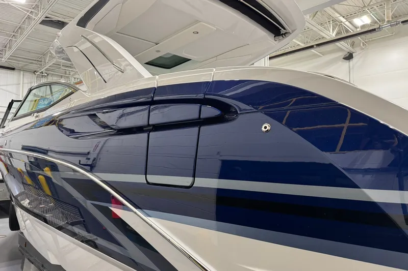 Slide: The Image of 2026 Formula 360 Crossover Bowrider I/O in showroom, sleek blue and white design. - 6