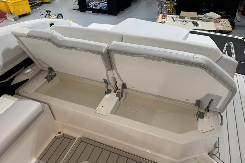 Slide: The Image of 2026 Formula 360 Crossover Bowrider I/O boat with open storage compartment and cushioned seating. - 71