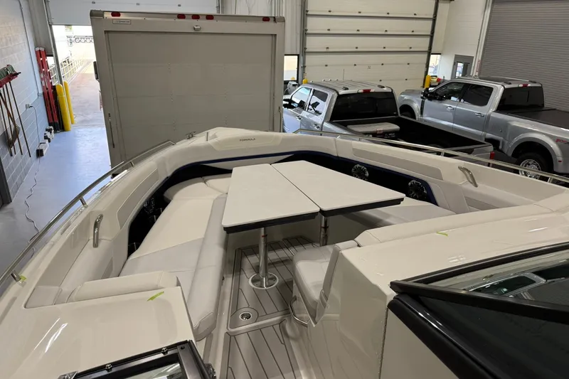 Slide: The Image of 2026 Formula 360 Crossover Bowrider I/O interior with seating and table in a garage setting. - 117