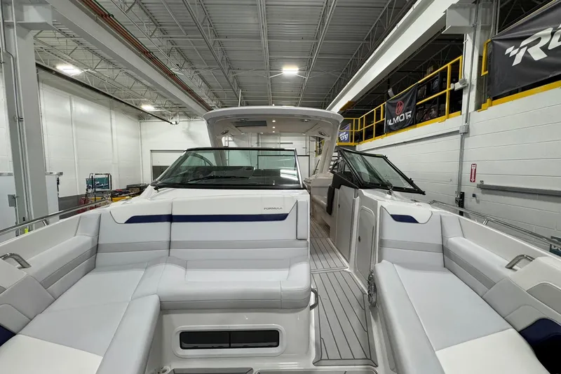 Slide: The Image of 2026 Formula 360 Crossover Bowrider I/O in showroom, featuring sleek white seating and modern design. - 105