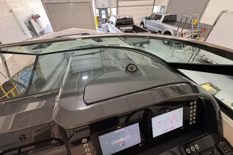 Slide: The Image of 2026 Formula 360 Crossover Bowrider I/O dashboard with digital controls in a garage setting. - 193