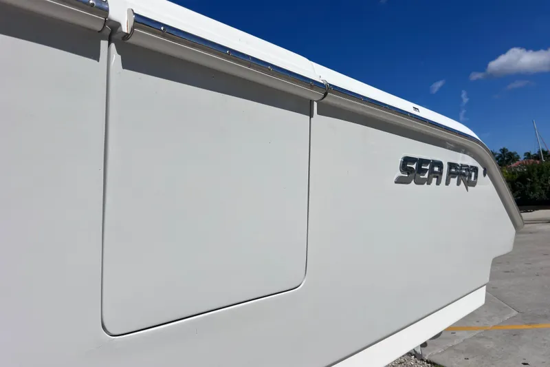 Slide: The Image of 2022 Sea Pro 320 DLX Offshore boat side view with logo under clear blue sky. - 23