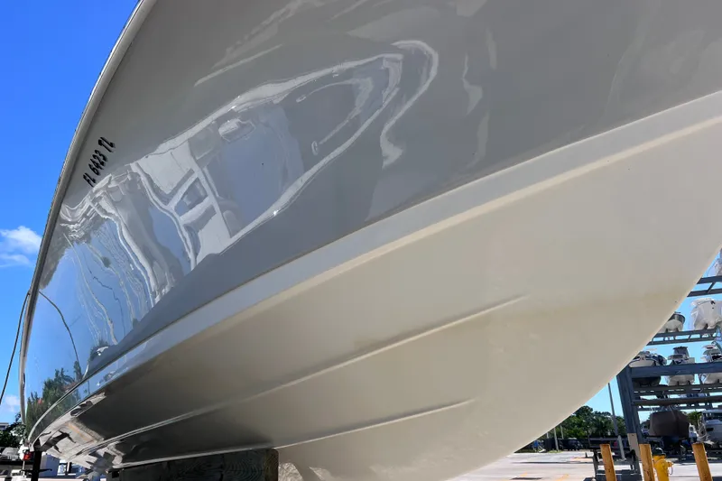 Slide: The Image of 2022 Sea Pro 320 DLX Offshore boat hull reflecting surroundings under clear blue sky. - 20