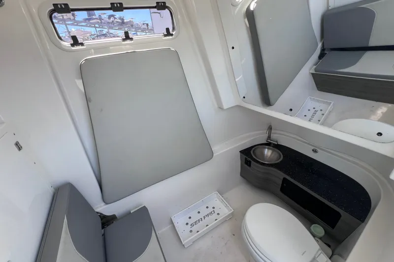Slide: The Image of 2022 Sea Pro 320 DLX Offshore boat interior with sink, toilet, and seating area. - 86