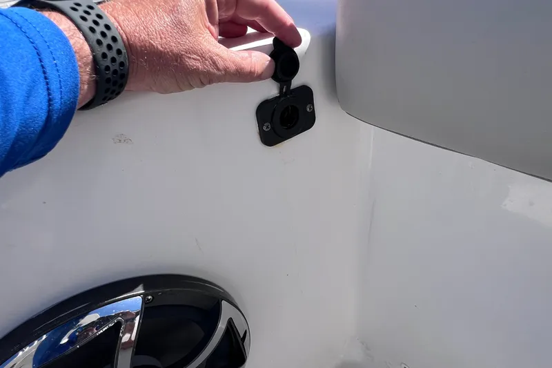 Slide: The Image of Hand opening a socket cover on a 2022 Sea Pro 320 DLX Offshore boat. - 36