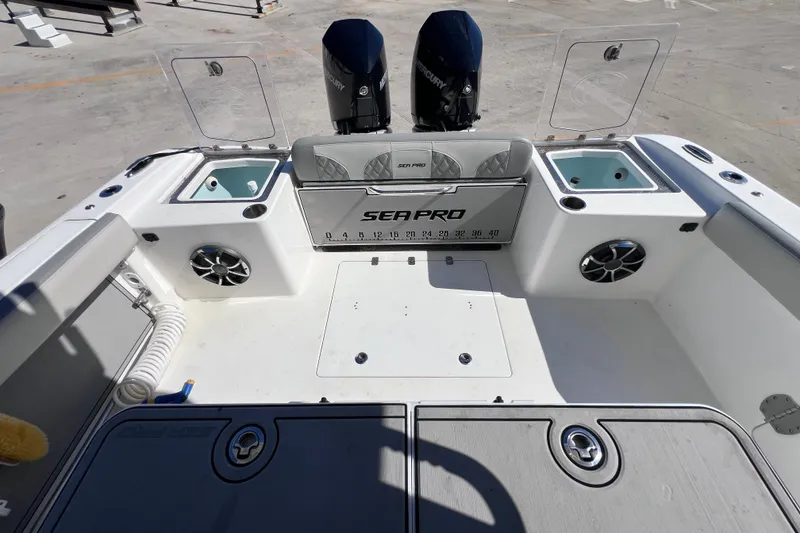 Slide: The Image of 2022 Sea Pro 320 DLX Offshore boat deck with dual engines and storage compartments. - 32