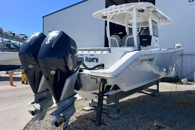 Slide: The Image of 2022 Sea Pro 320 DLX Offshore boat with dual Mercury engines, docked outdoors. - 17