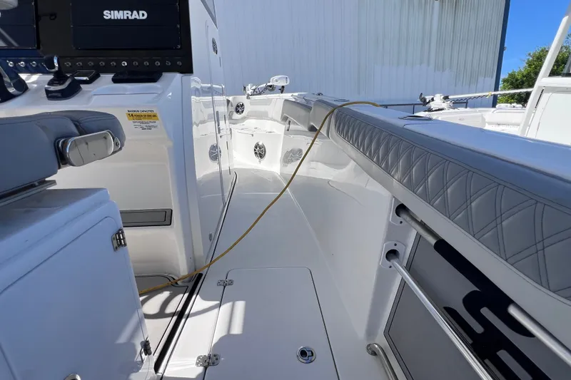 Slide: The Image of 2022 Sea Pro 320 DLX Offshore boat interior with Simrad electronics and cushioned seating. - 47