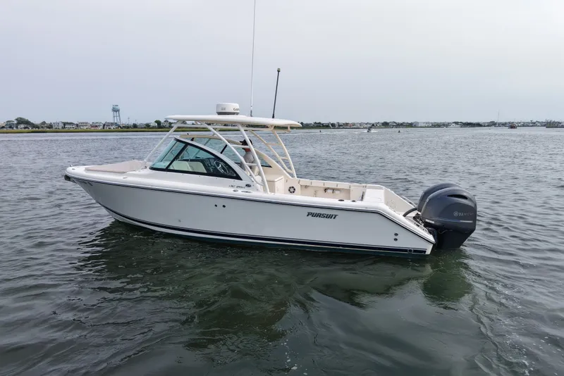 Slide: The Image of 2014 Pursuit DC 265 Dual Console boat on calm water. - 4