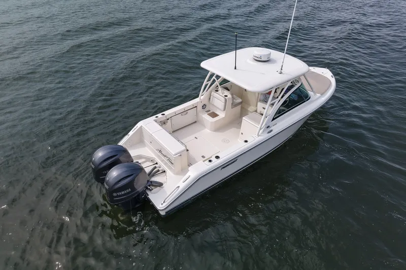 Slide: The Image of 2014 Pursuit DC 265 Dual Console boat on water, featuring twin Yamaha engines. - 10