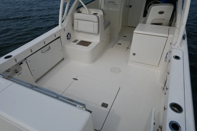 Slide: The Image of 2014 Pursuit DC 265 Dual Console boat interior with seating and storage compartments. - 29