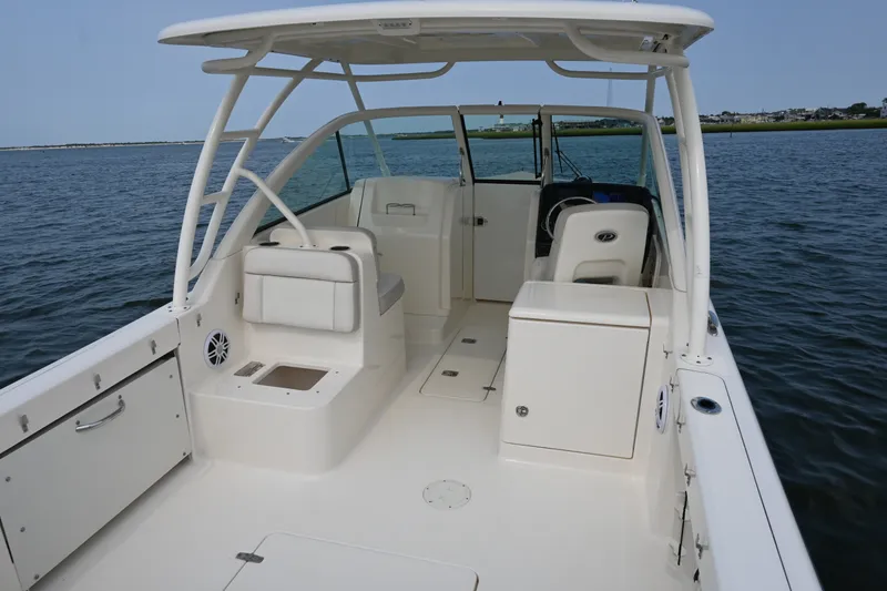 Slide: The Image of 2014 Pursuit DC 265 Dual Console boat interior on calm water. - 17
