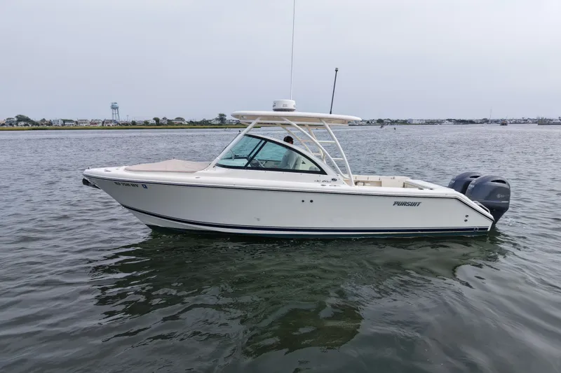 Slide: The Image of 2014 Pursuit DC 265 Dual Console boat on calm water. - 5