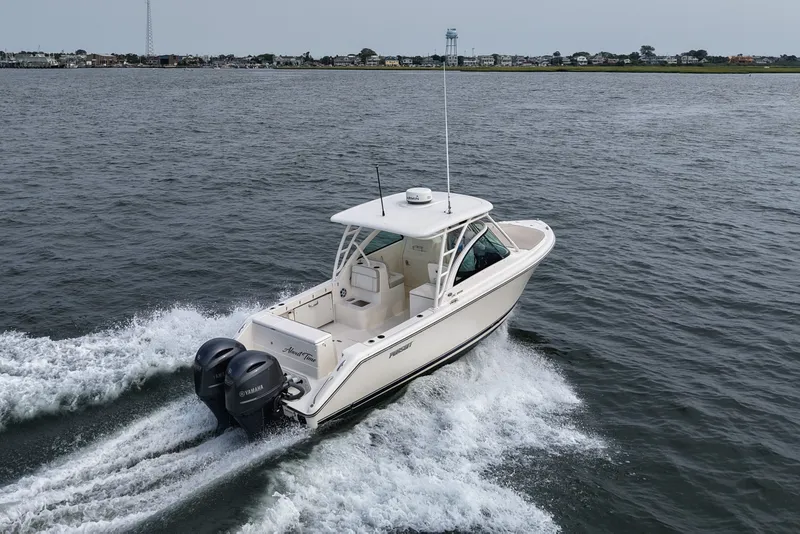 Slide: The Image of 2014 Pursuit DC 265 Dual Console boat cruising on open water. - 15