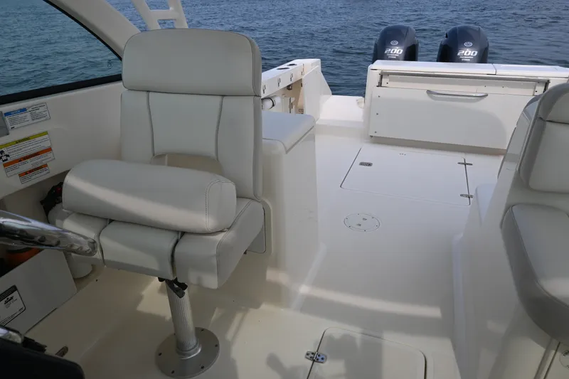 Slide: The Image of 2014 Pursuit DC 265 Dual Console boat interior with seating and twin engines. - 23