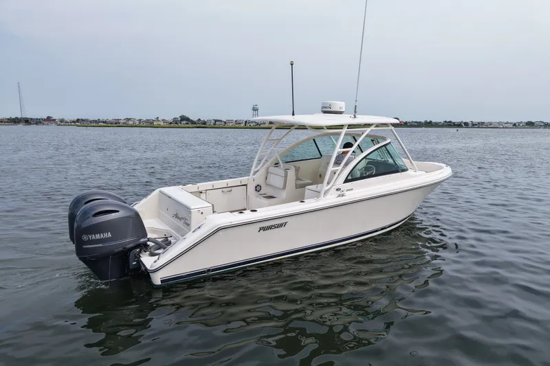 Slide: The Image of 2014 Pursuit DC 265 Dual Console boat on calm water with Yamaha engines. - 2