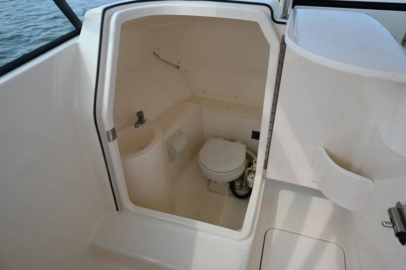 Slide: The Image of 2014 Pursuit DC 265 Dual Console boat interior with compact marine toilet. - 33
