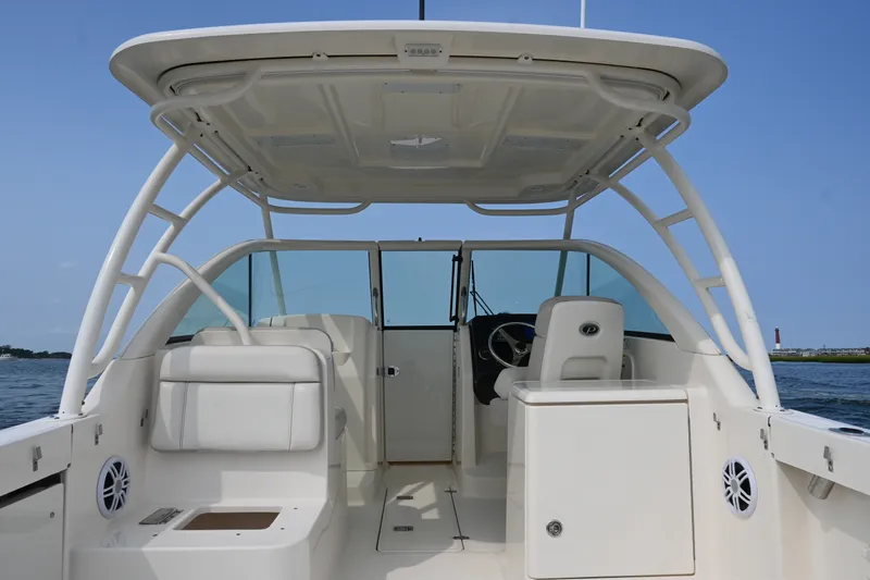 Slide: The Image of 2014 Pursuit DC 265 Dual Console boat interior with helm and seating, on open water. - 18