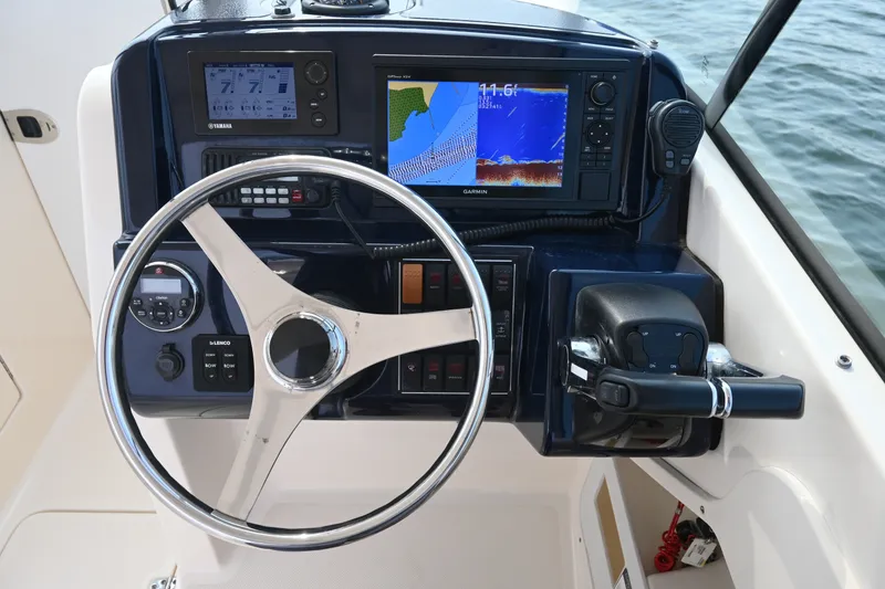 Slide: The Image of Steering console of a 2014 Pursuit DC 265 Dual Console boat with navigation displays. - 22