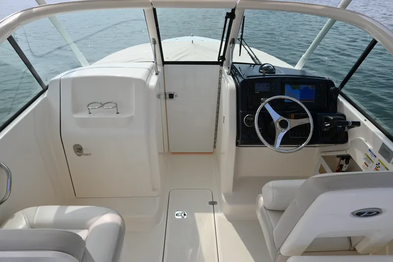 Slide: The Image of 2014 Pursuit DC 265 Dual Console boat interior with steering wheel and dashboard. - 19