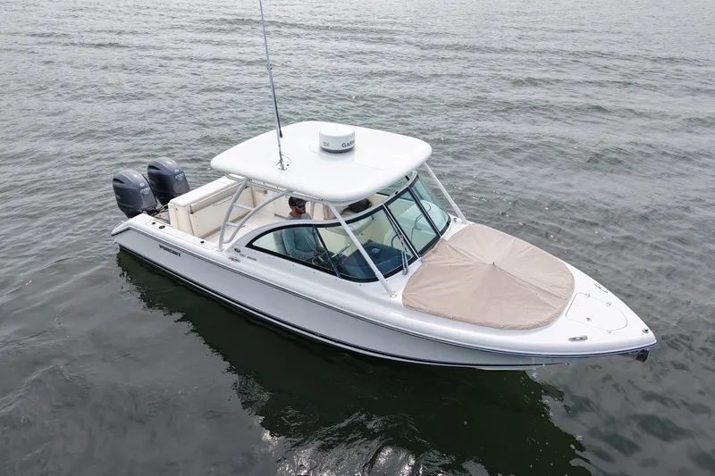 Slide: The Image of 2014 Pursuit DC 265 Dual Console boat on calm water. - 11
